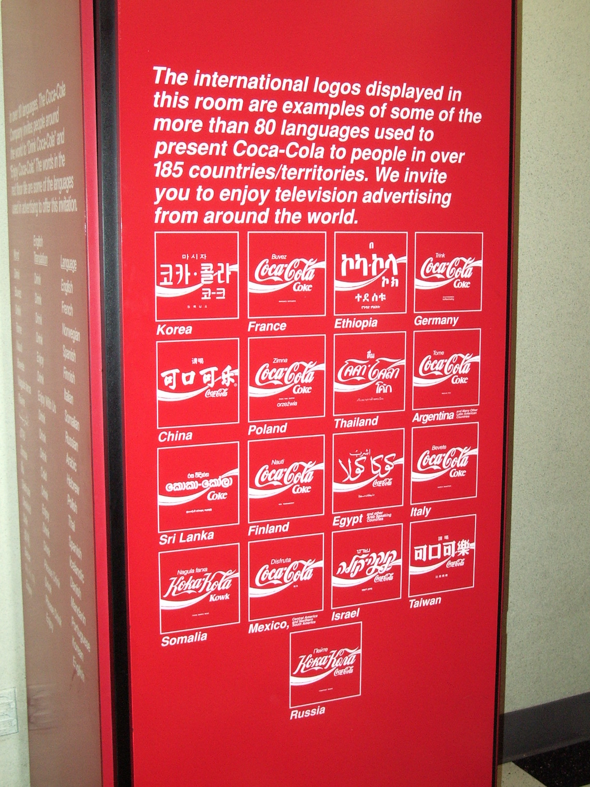 Sign displaying Coca Cola brand logos in different languages