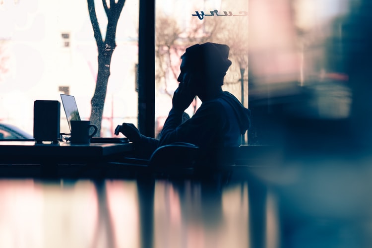Man sitting in cafe with laptop